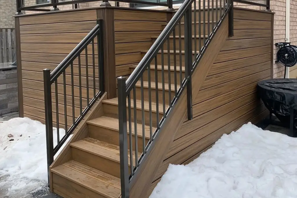 Brown composite deck and stairs with black aluminum picket railings