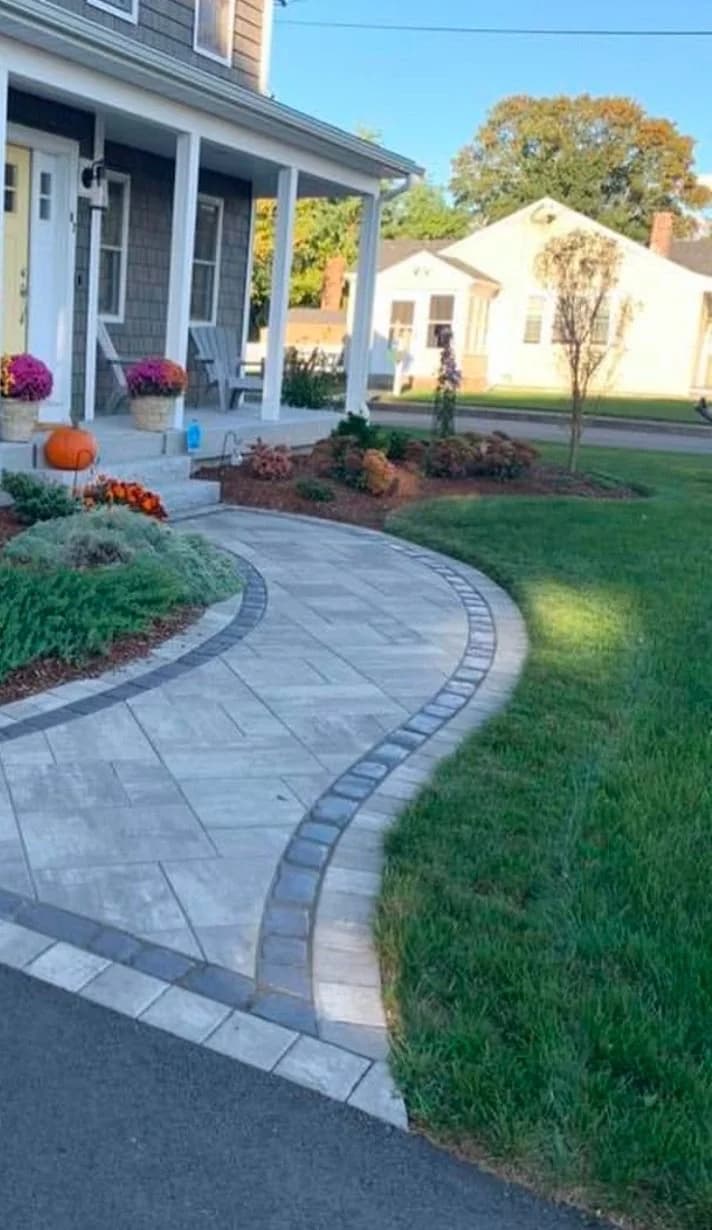 Curved stone walkway leading to a white residential front porch