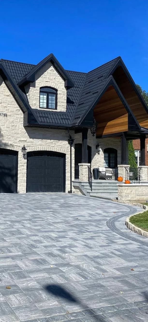 Residential front entrance with steps and a grey interlocking driveway